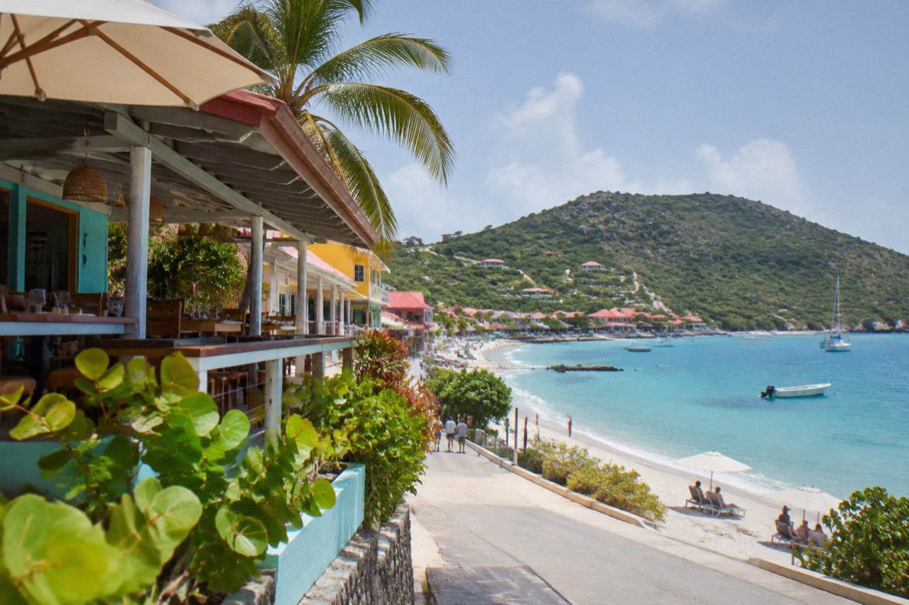 A small boat anchored in turquoise Caribbean water near a green hillside