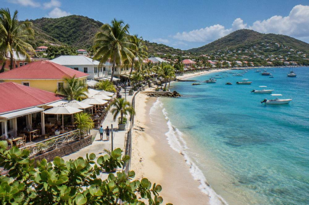 Shops and cafes along a sunny Caribbean promenade with palm trees