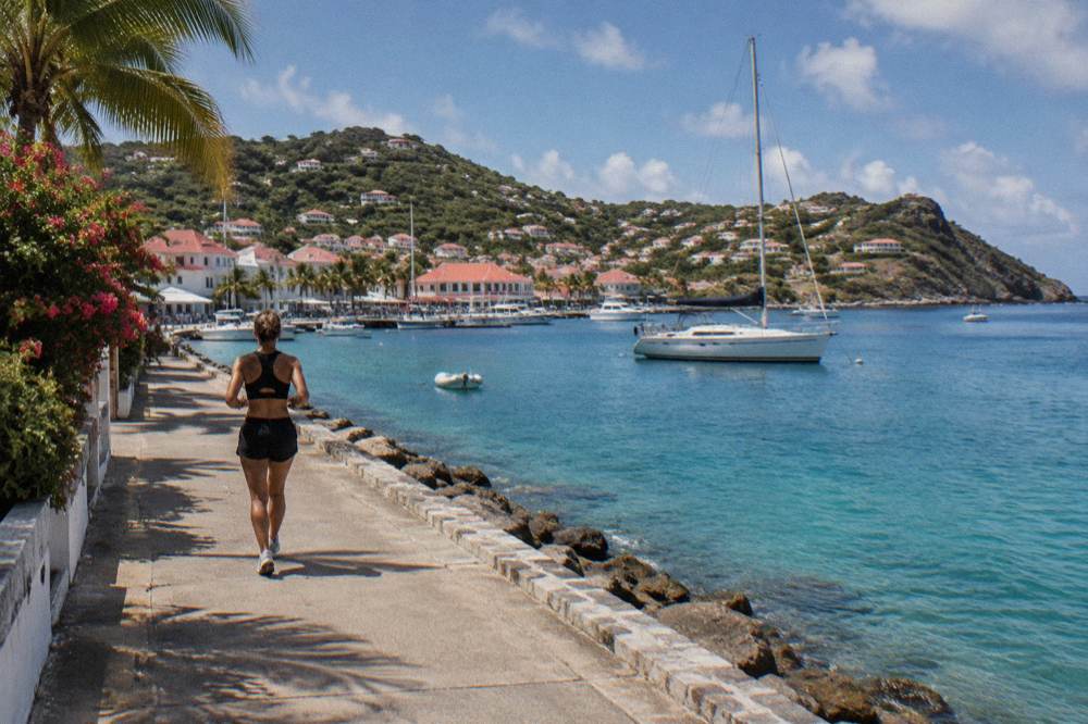 A calm bay in St Barts with a moored sailboat and rocky headland