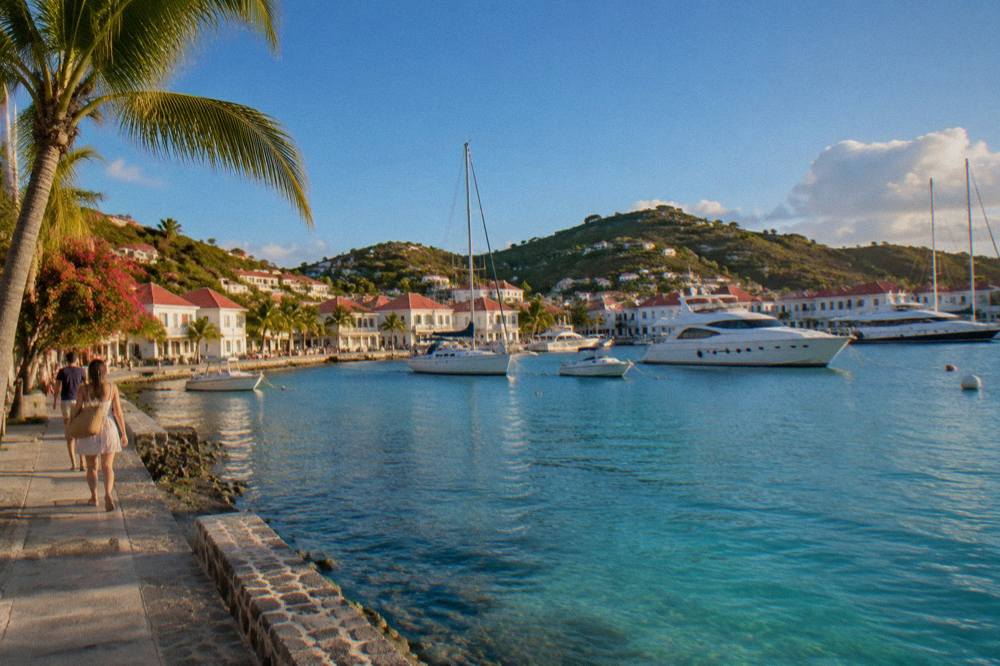 The harbor front of Gustavia with white buildings and moored yachts in winter light