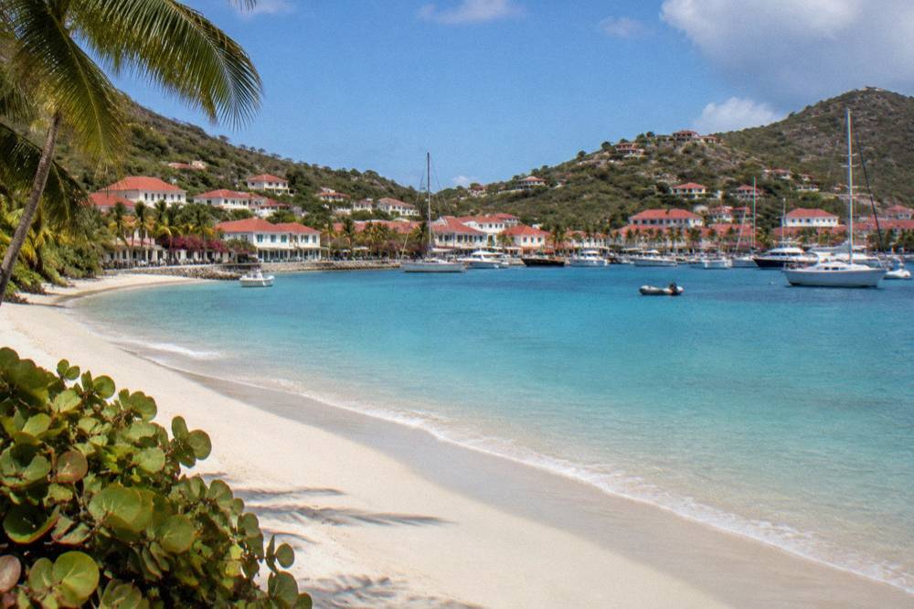 An empty crescent of pale sand and calm water on a quiet morning in St Barts