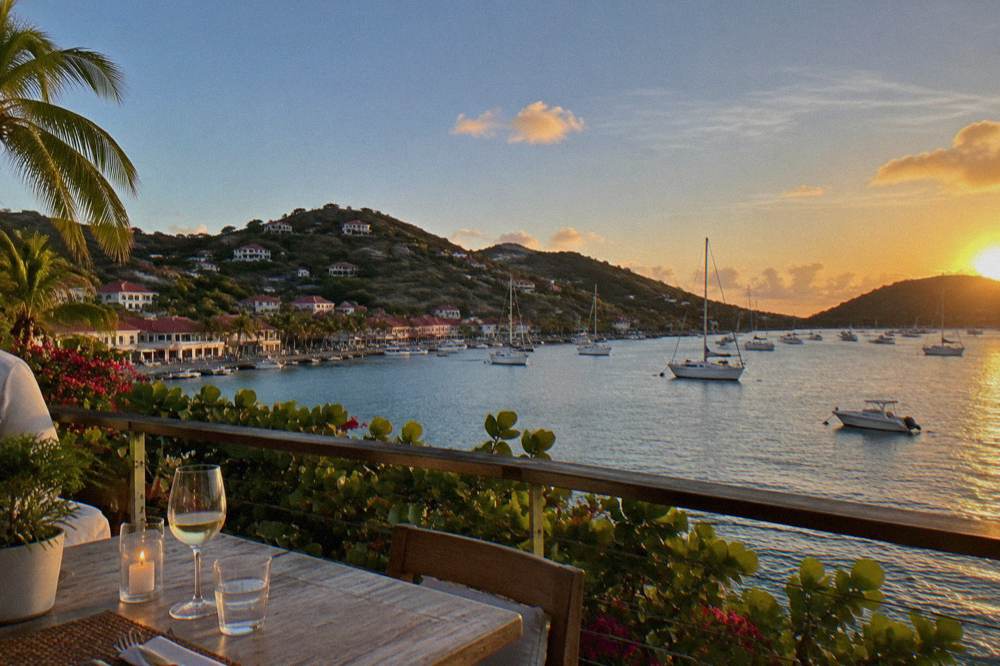 A terrace table set above the water at dusk on the St Barts coast
