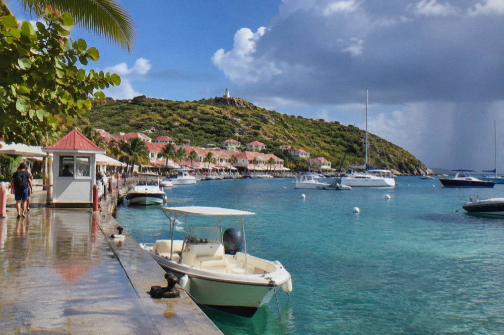 A Caribbean ferry terminal quay with a small passport control booth and moored boats