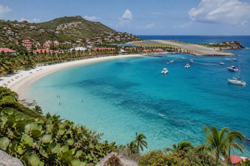 Aerial view of St Jean bay in St Barts with the airport runway visible along the shoreline