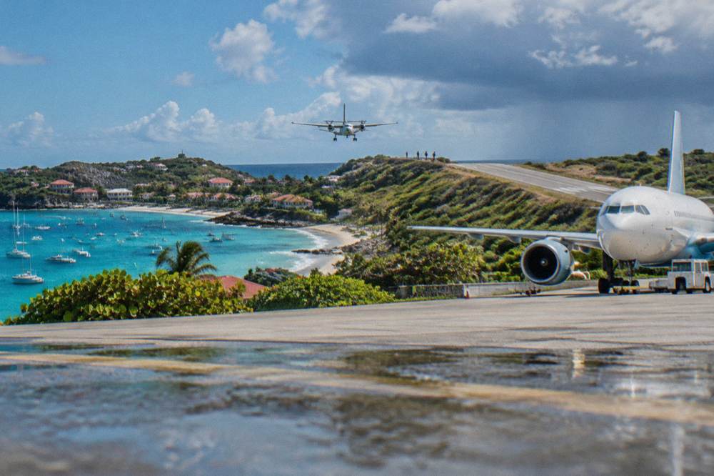 A wide-body jet at a large Caribbean airport terminal seen from the apron