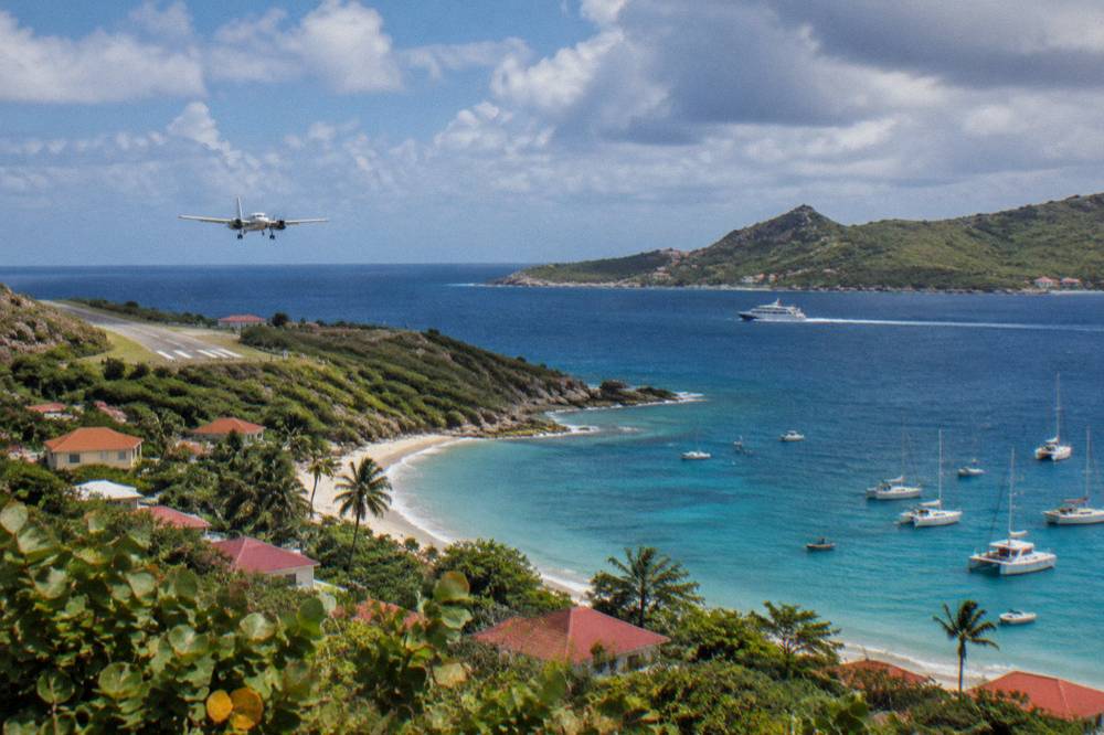 A fast ferry boat crossing open blue water toward a green island coastline