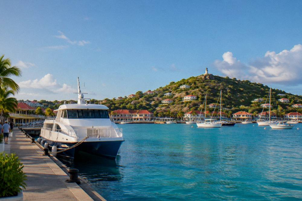 A fast passenger ferry tied at a small Caribbean marina dock in morning light