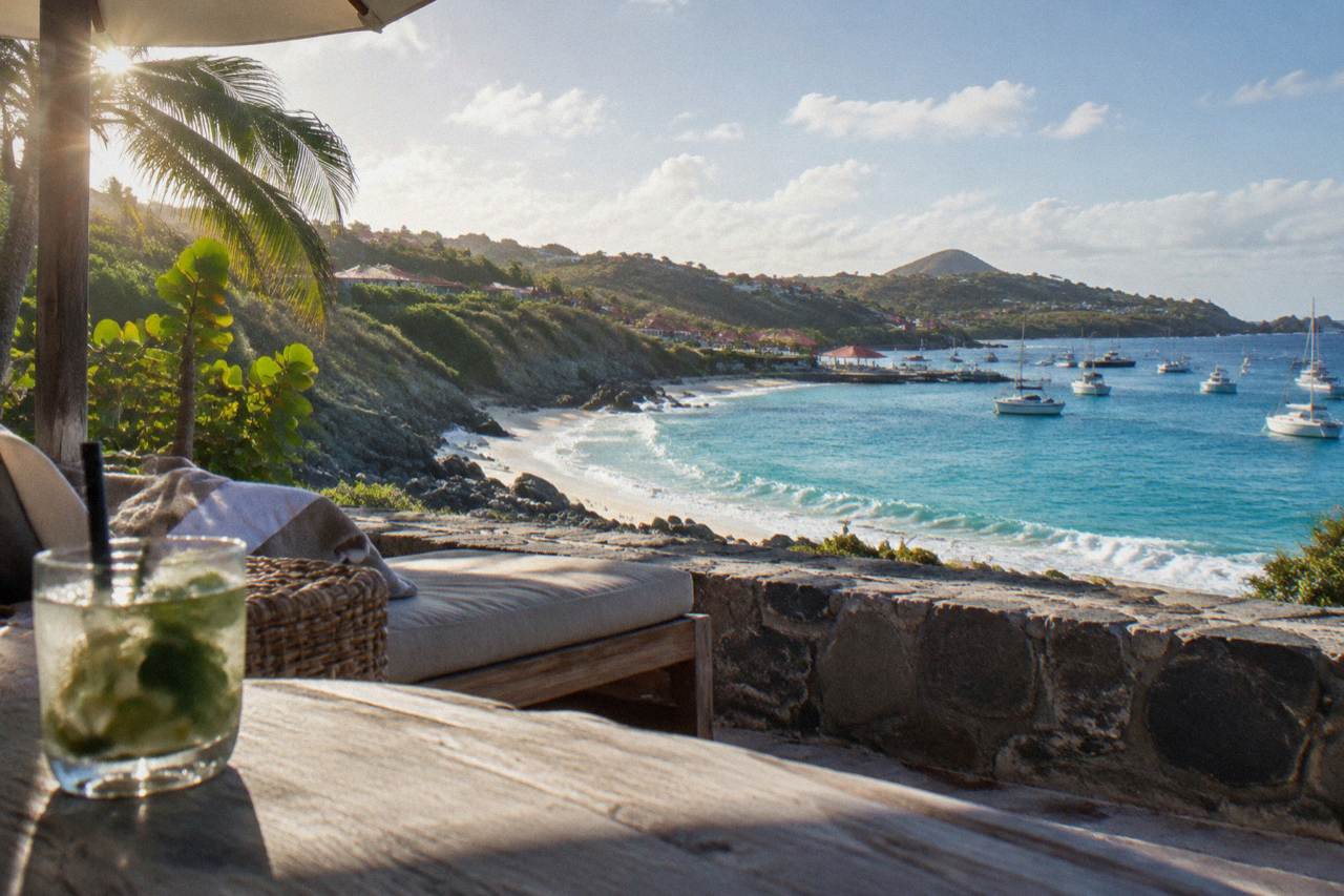 A hillside hotel terrace above a small curved bay on a tropical Caribbean island