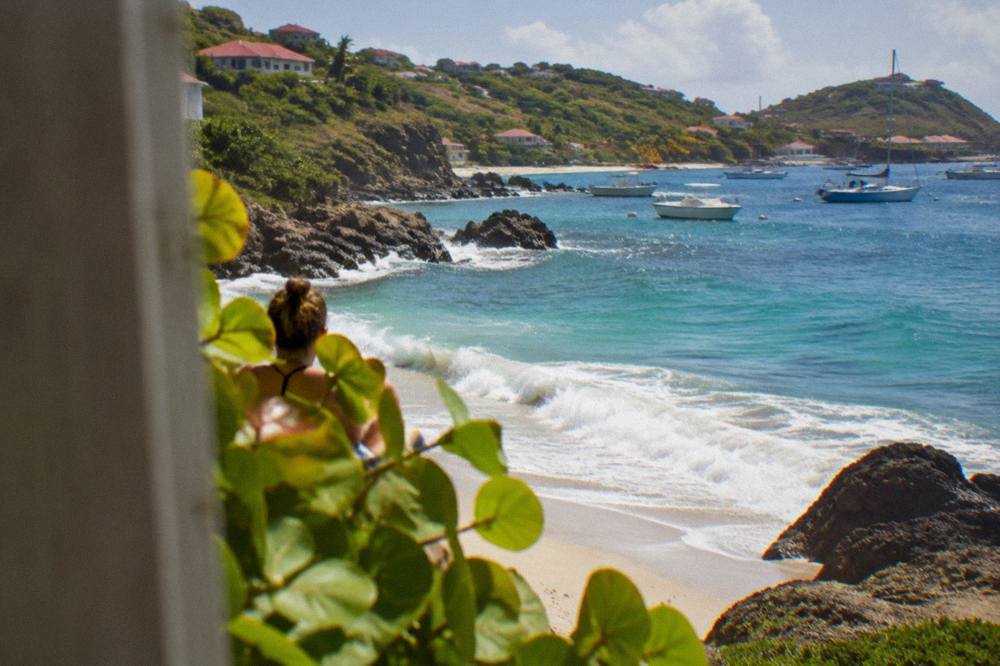 An evening view of a Caribbean bay with a few lights along the shore