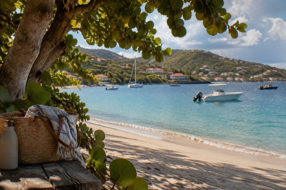White sand beach with gentle waves and green hills in the background on a sunny day