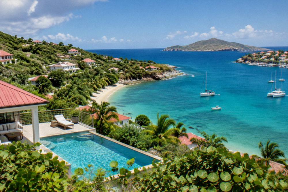A hillside villa with a terrace pool looking over the sea toward a neighbouring island