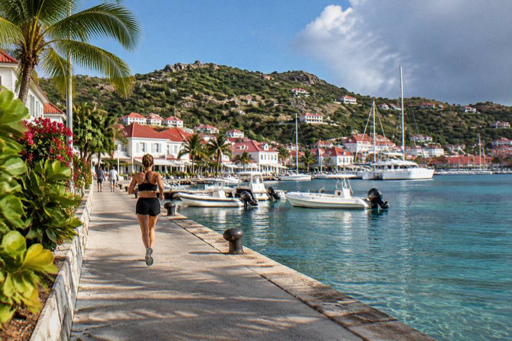 White buildings with red roofs around a small harbor filled with yachts