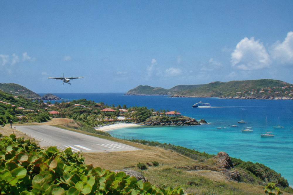A passenger ferry cutting across open blue water between green Caribbean islands