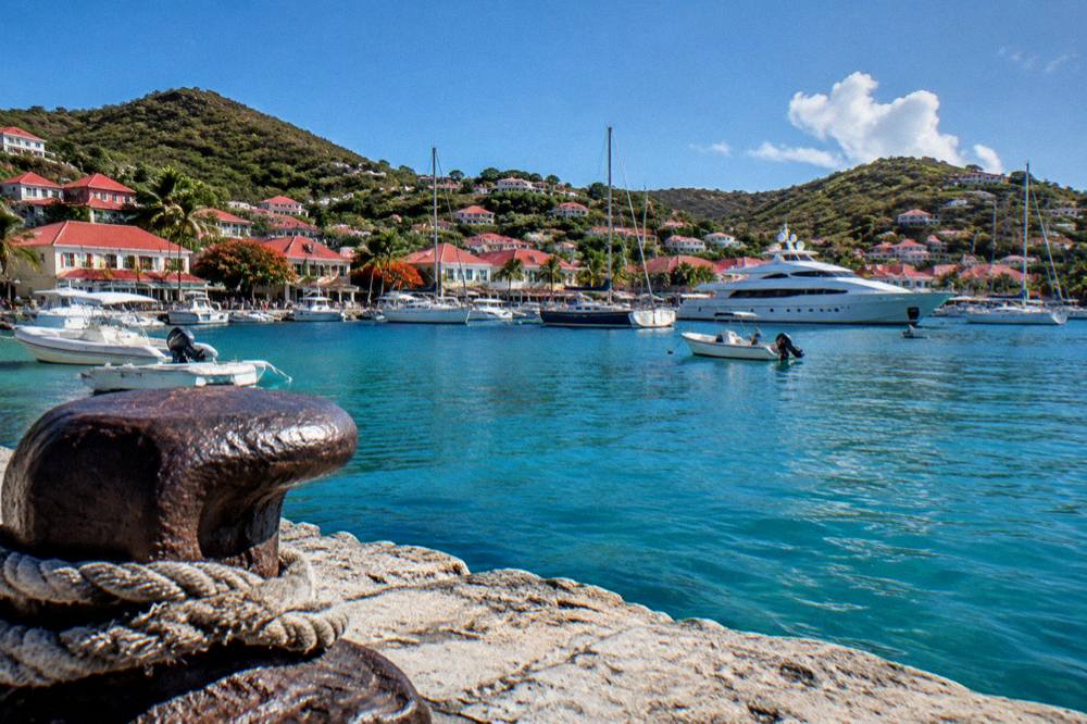 Red-roofed houses around a harbour full of yachts in Gustavia St Barts under a clear sky