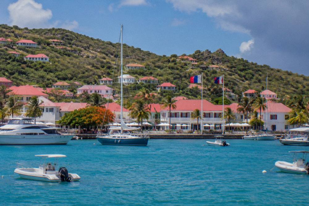 French and local flags flying above a Caribbean harbor frontage