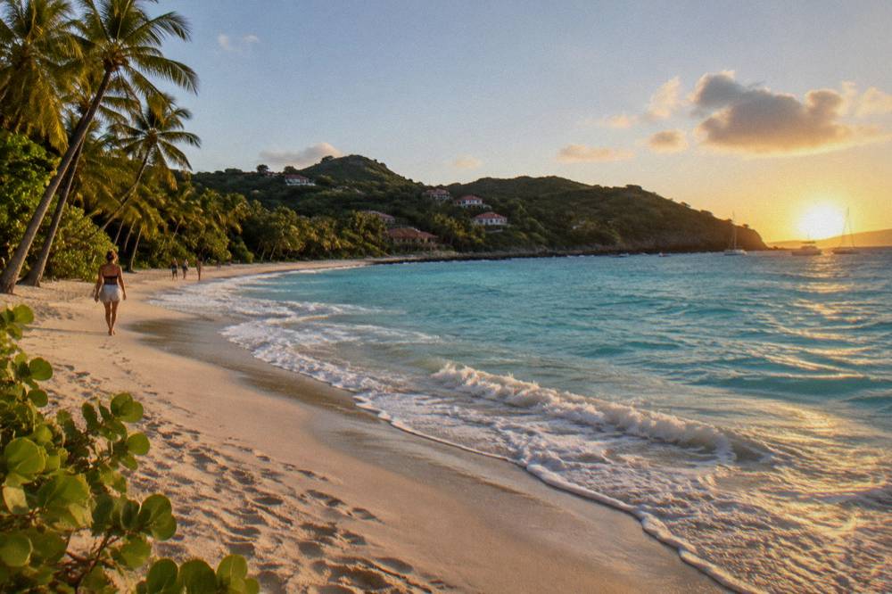 Turquoise water and pale sand under a clear sky at a Caribbean beach in late afternoon light