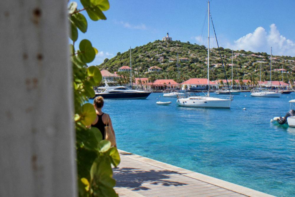 Sailboats and motor yachts anchored in Gustavia harbor under a clear sky in St Barts