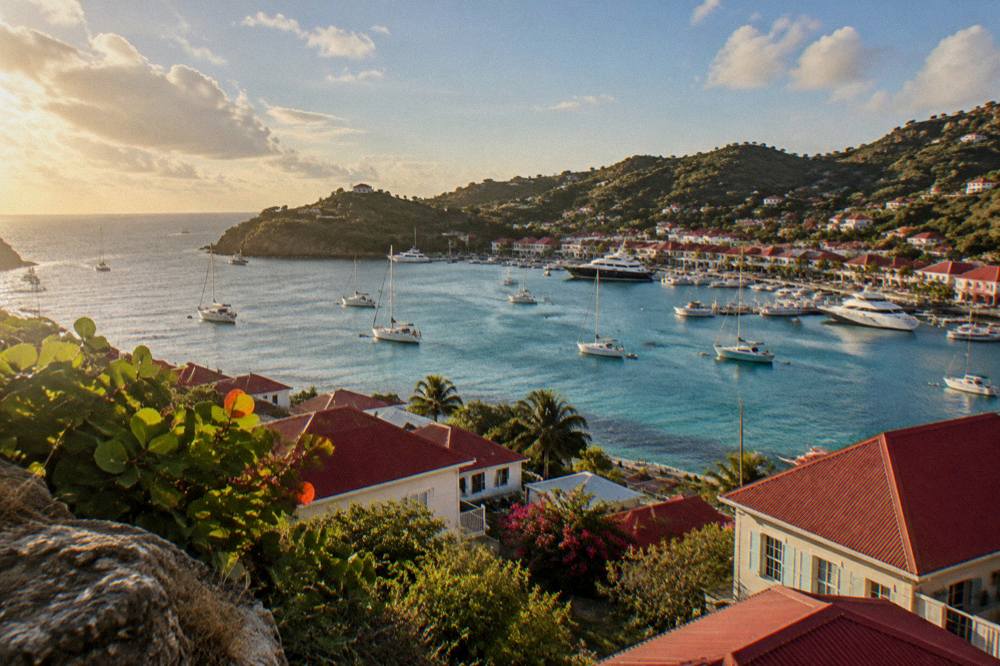 Hillside view over red-roofed buildings and the harbor of Gustavia in St Barts at dusk