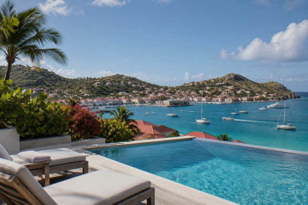 A villa pool deck with sun loungers and a wide view over turquoise Caribbean water