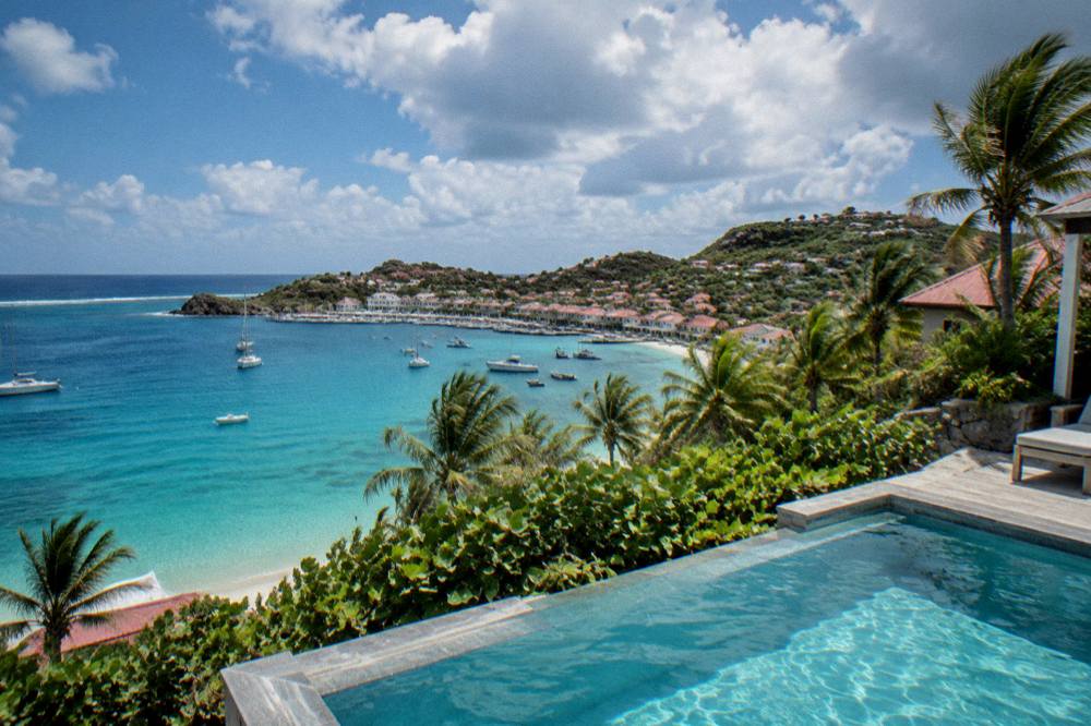 A private villa with a pool on a hillside overlooking the sea