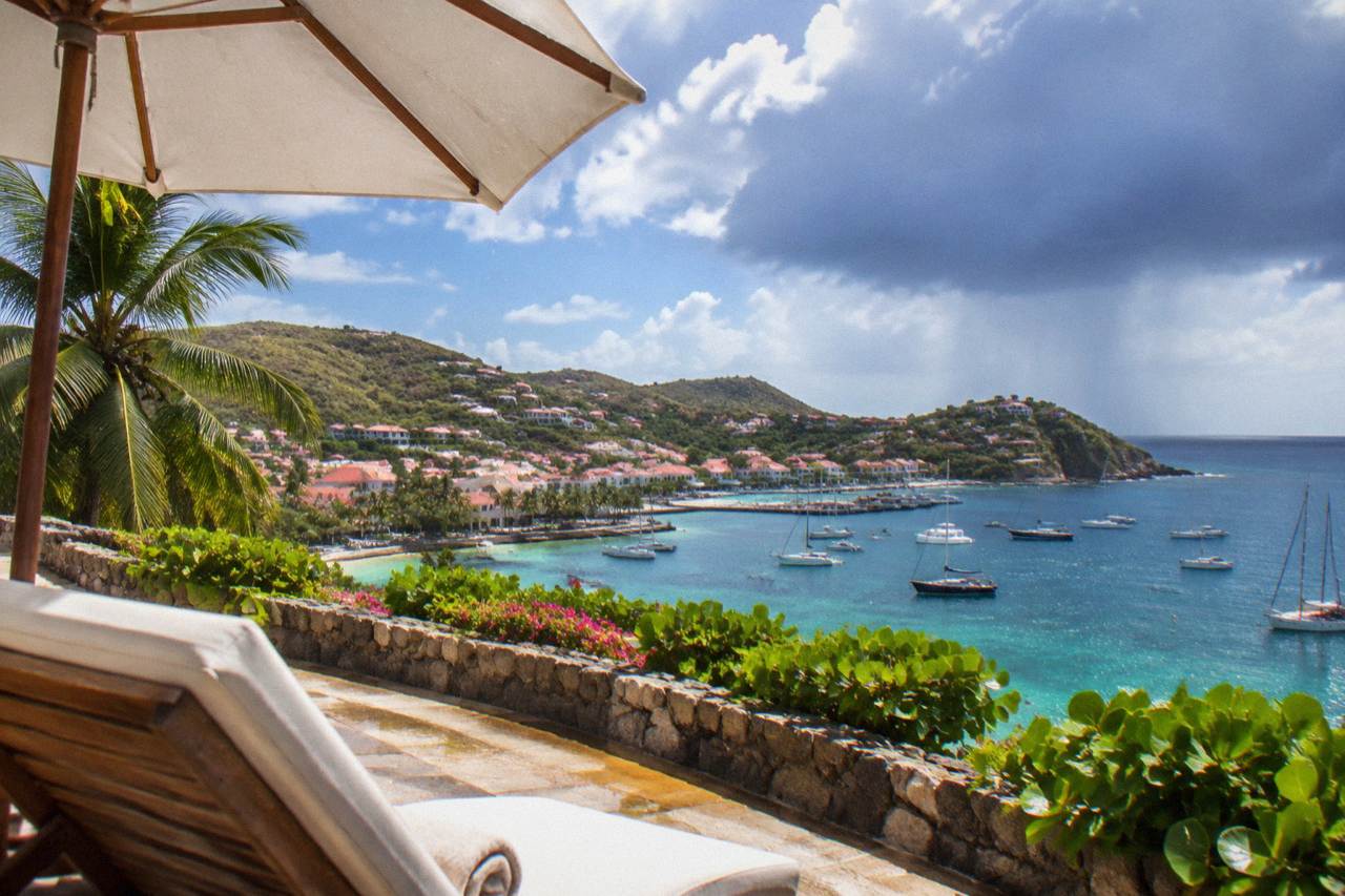 A hillside luxury hotel terrace above a turquoise bay on a Caribbean island