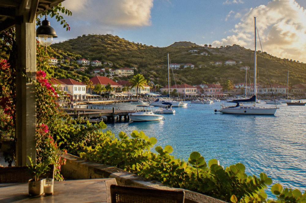 White hotel villas with red roofs above a curved Caribbean beach