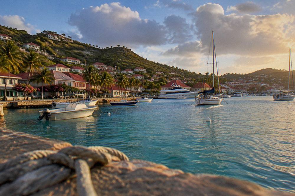 Red-roofed houses stacked above a small harbour filled with sailboats and yachts
