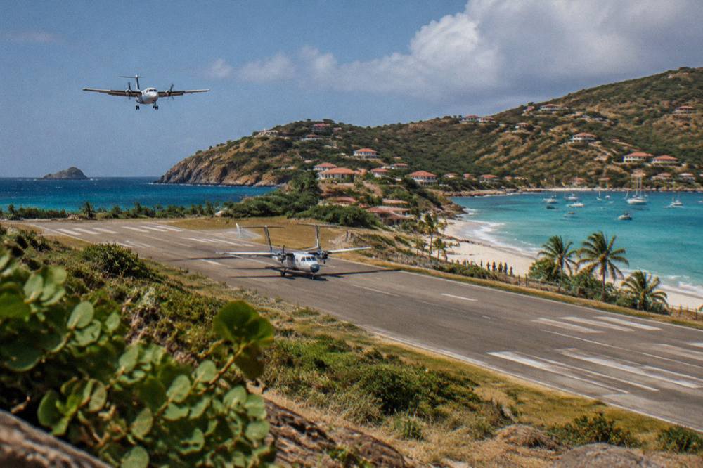 A small turboprop aircraft on the short runway at Saint-Jean beside the beach