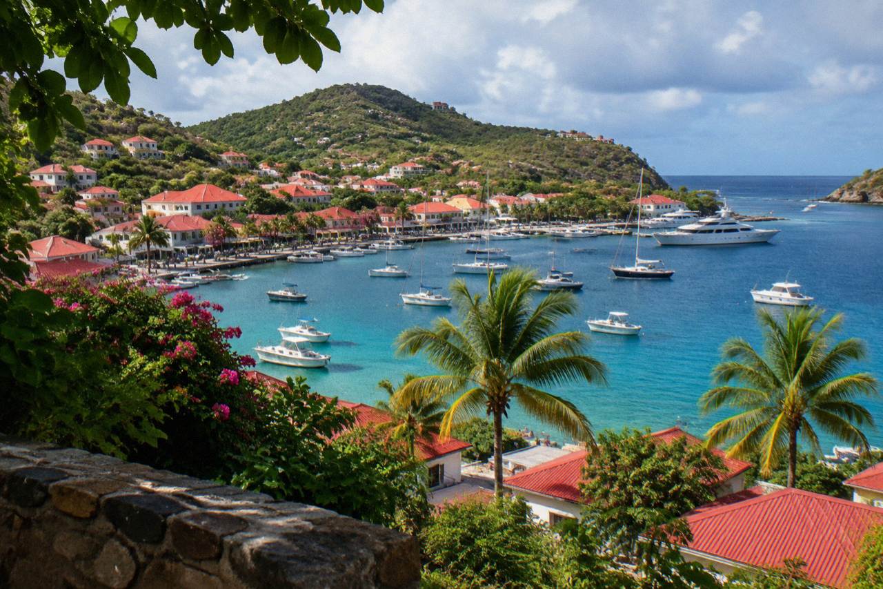 Turquoise water and green hills seen from above a small Caribbean island harbour