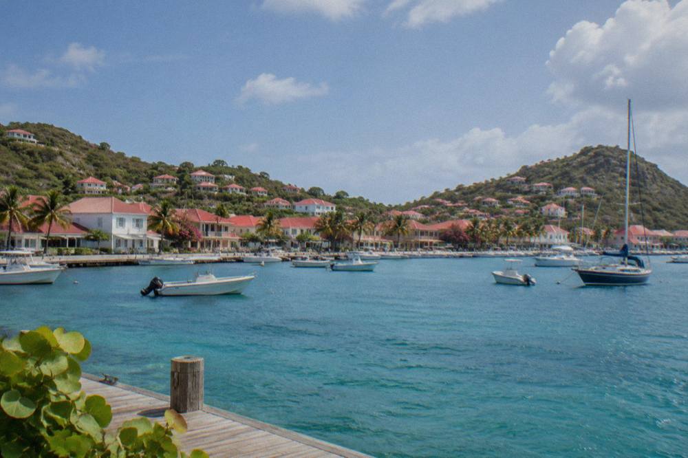 A small Caribbean town of white and red-roofed buildings around a yacht harbour