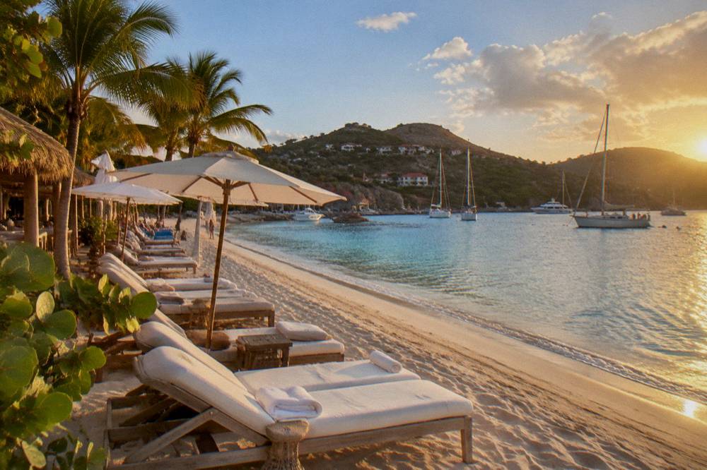 Sailing yachts moored in a small Caribbean harbor at golden hour