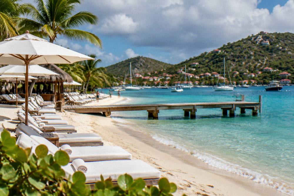 A wooden jetty extending over shallow turquoise water toward a beach