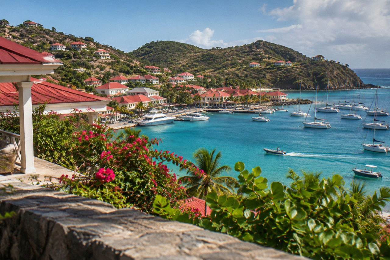 A small hillside hotel with red roofs looking down over a turquoise bay in St Barts