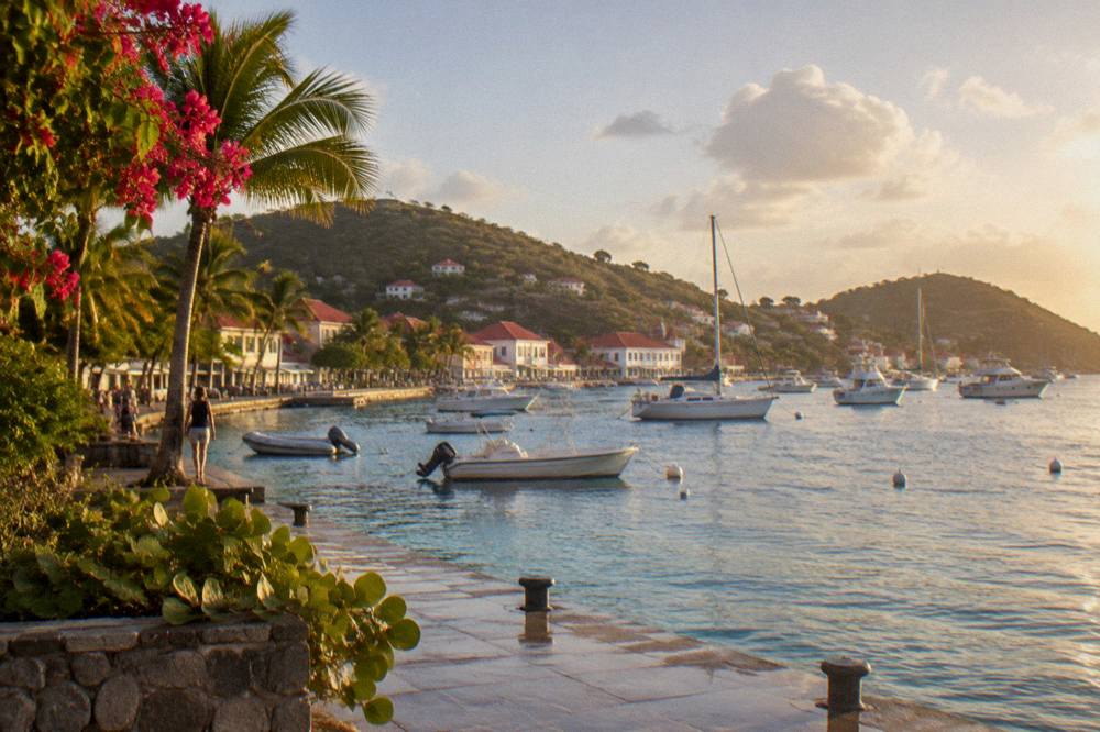 The harbour of Gustavia with white buildings and moored boats at golden hour