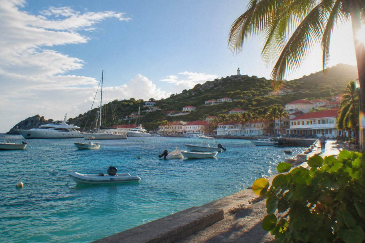 Yachts moored in Gustavia harbor with red roofs rising up the hillside