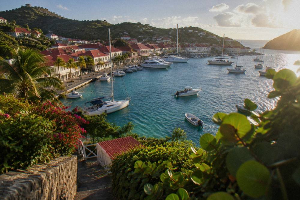 Red-roofed buildings of Gustavia rising above the quay with yachts moored in the harbor