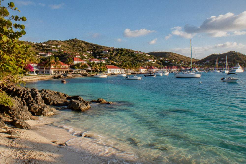 Small shell-strewn cove at the western edge of Gustavia with clear water and rocks