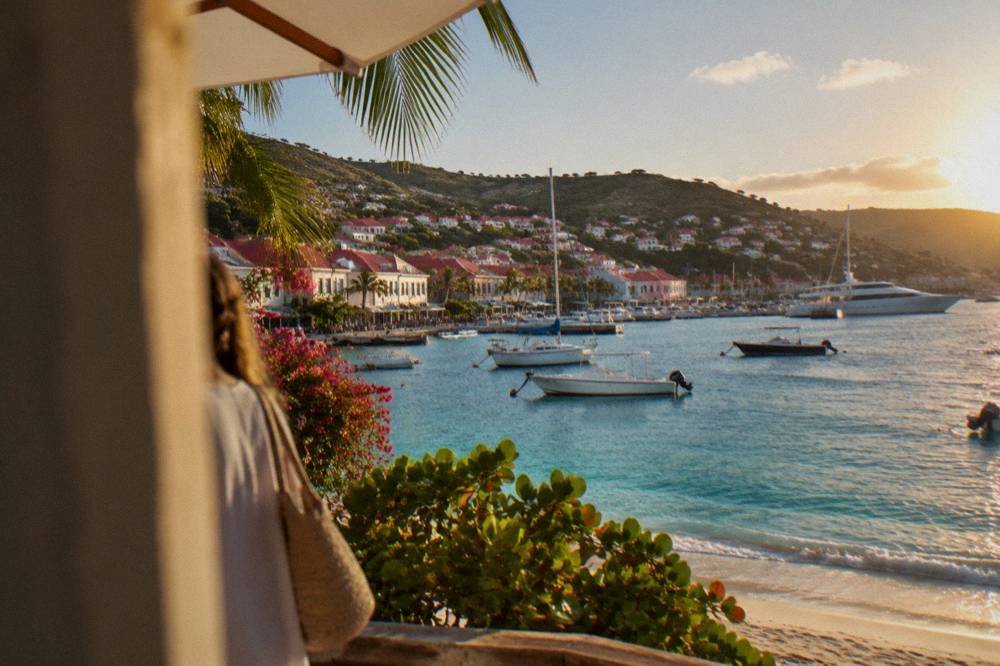 White sand beach with turquoise water and green hills on the south coast of St Barts