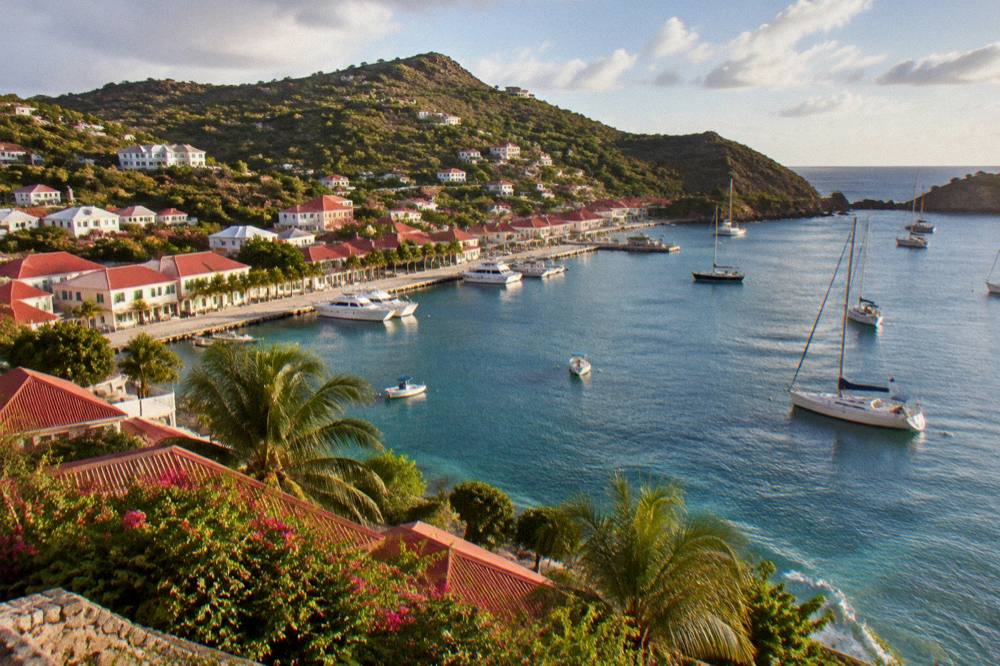 Sailboat anchored in a quiet bay with rocky hills on the coast of St Barts