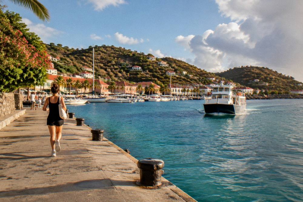 A small ferry approaching a Caribbean harbour with green hills behind