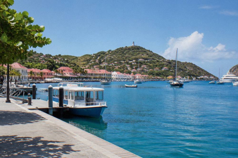 A ferry terminal dock with a small passenger boat moored beside it under a clear sky