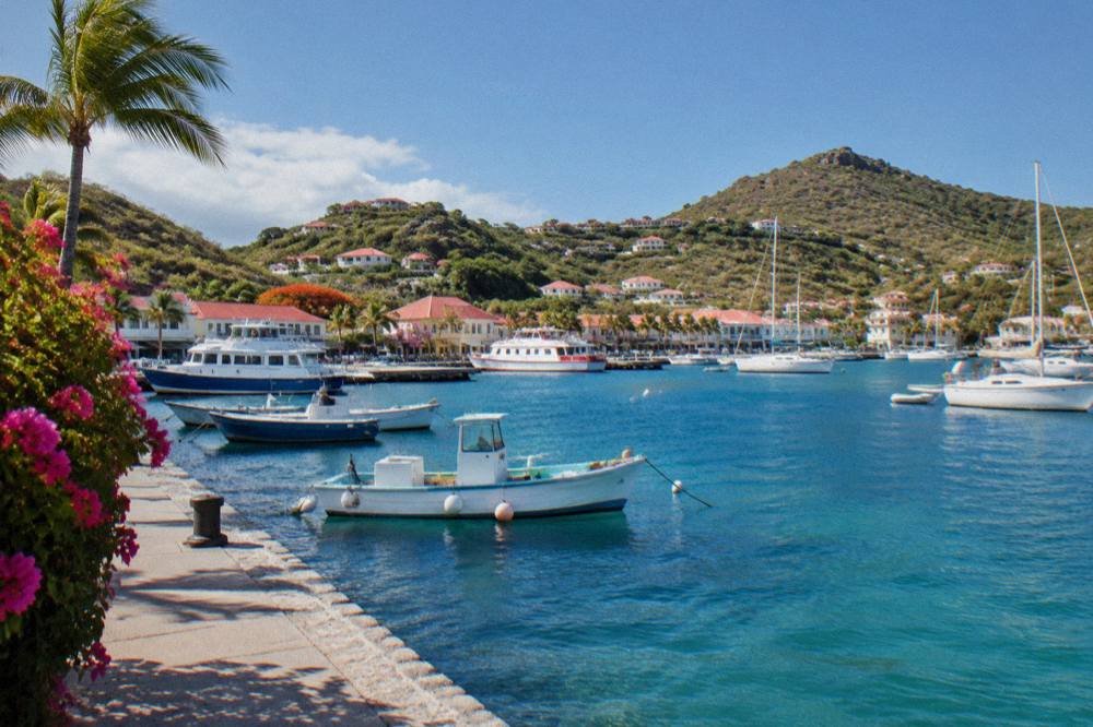 The harbour front of Gustavia with fishing boats and ferries at their moorings under a clear sky