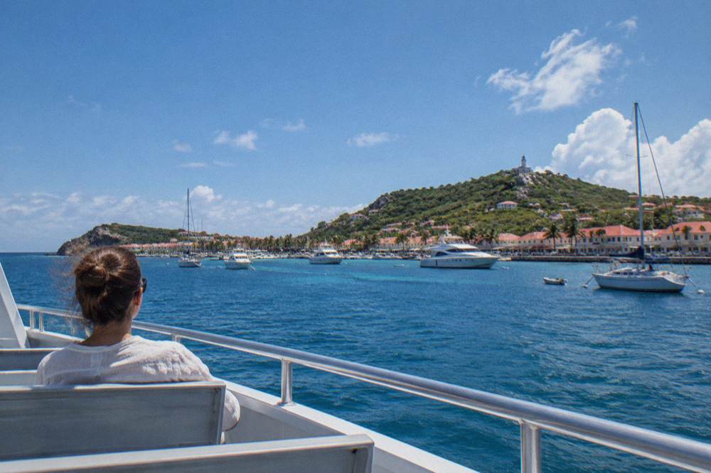 A passenger seated mid-deck on a ferry looking out toward the horizon over open sea