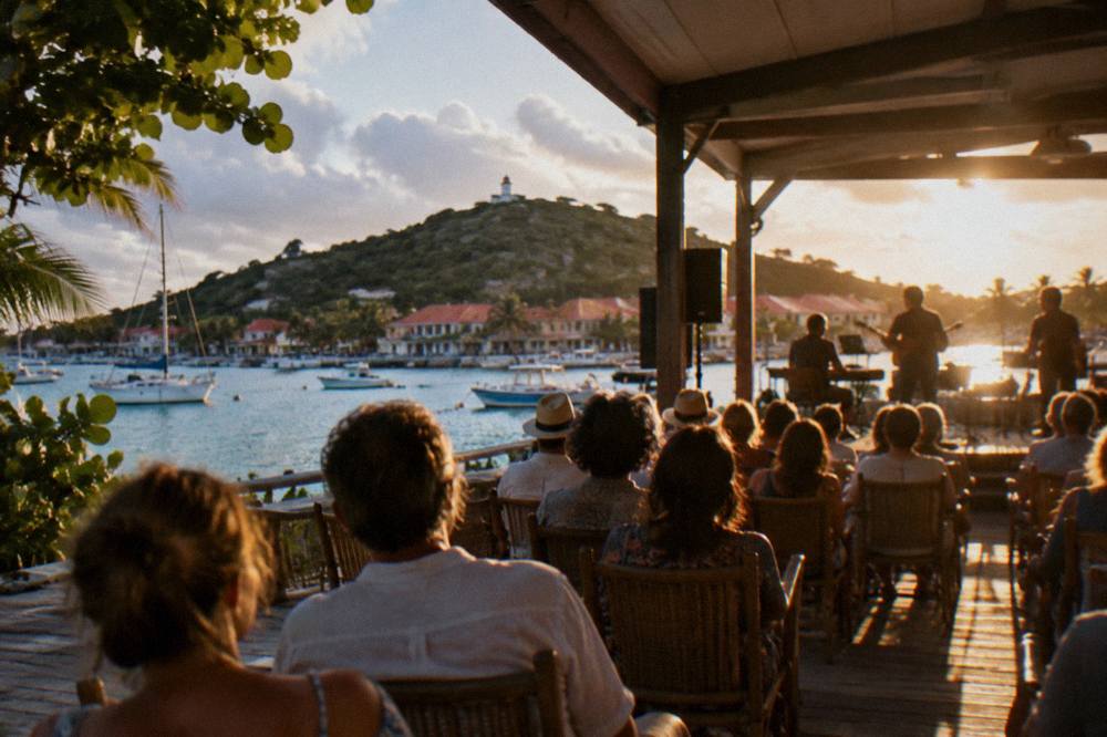 An evening concert audience seated in an open-sided island hall