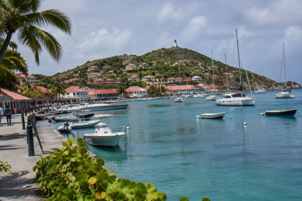 Red-roofed houses rising up a hillside above a small Caribbean harbour