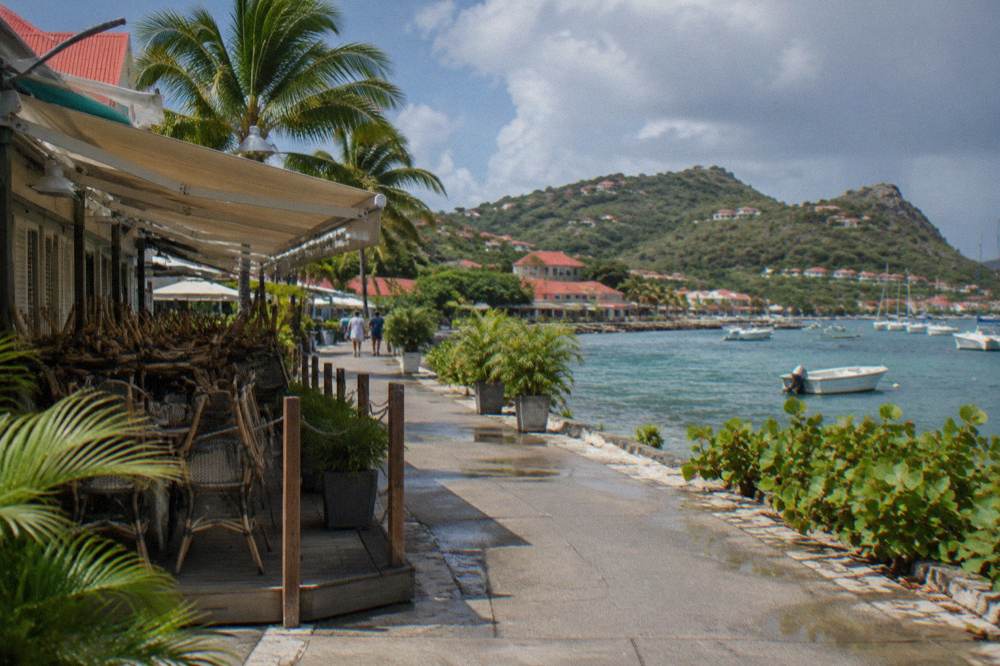 A closed beachfront restaurant terrace with chairs stacked during the low season