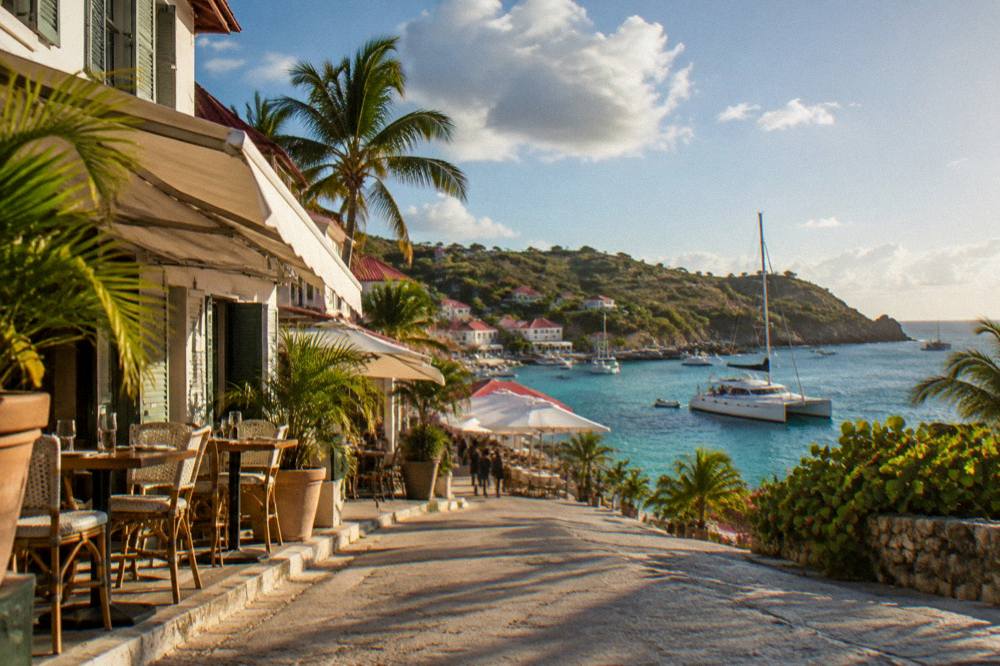 A catamaran at anchor in a quiet bay with lunch laid out on deck