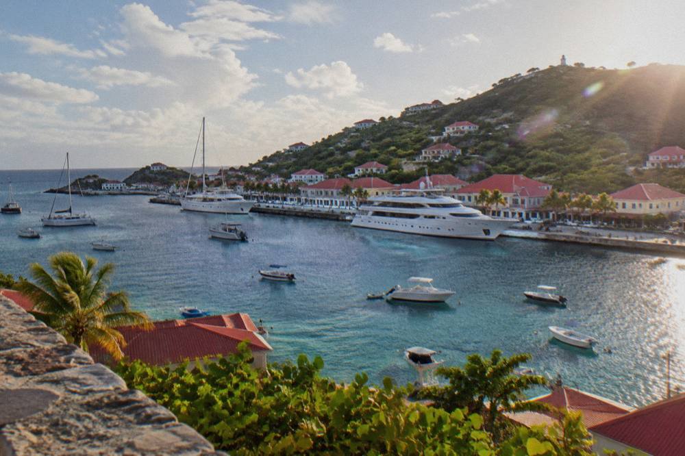 Yachts moored in Gustavia harbour with red-roofed buildings on the hillside