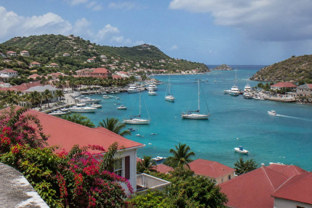 A view over red rooftops and a turquoise harbor on a Caribbean island