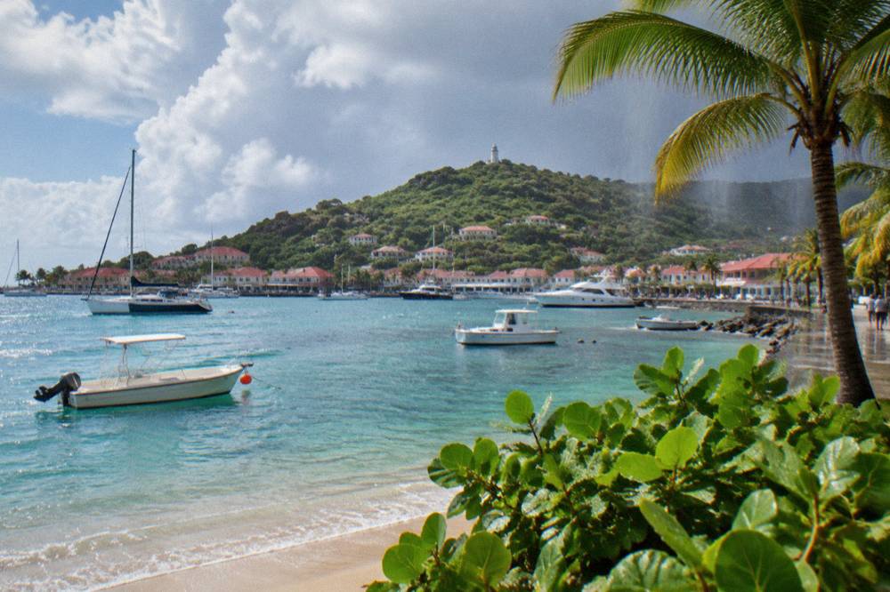 Rain falling over palm trees and a beach on a tropical island